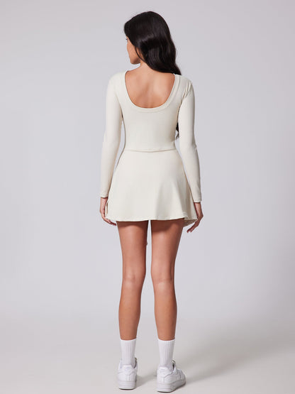 Woman wearing a white long-sleeve dress on a plain background