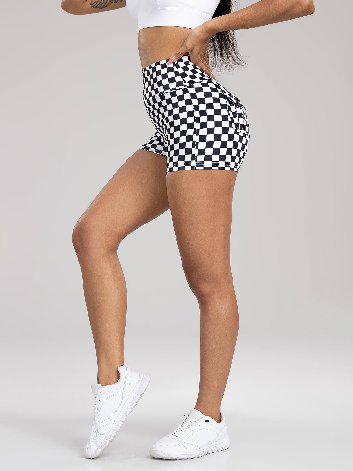 Person wearing black and white checkered shorts on a gray background