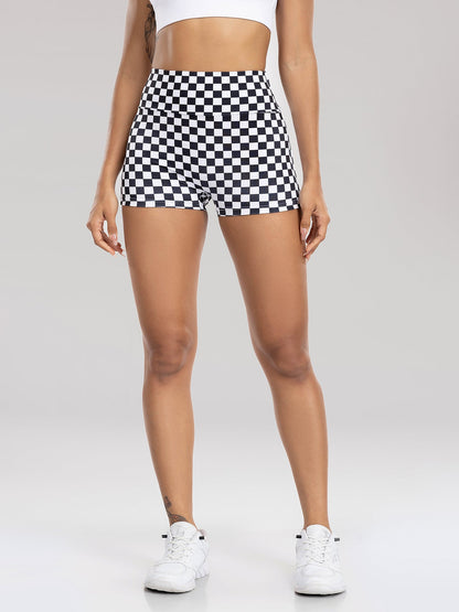 Person wearing black and white checkered shorts on a plain background